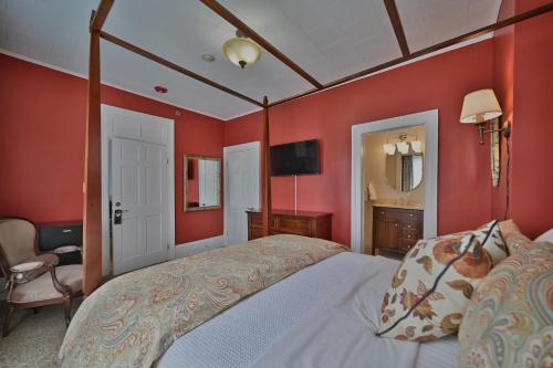 a bedroom with a large bed with red walls at Tom Quick Inn in Milford