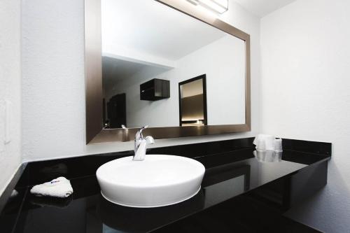 a bathroom with a white sink and a large mirror at Studio 6 Houston TX Medical Center NRG Stadium in Houston