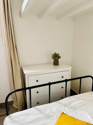 a bedroom with a bed and a dresser with a plant on it at Magnifique studio in Bagnolet