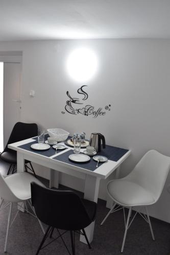 a table with white chairs and a white table with at Apartma VRBA Dobrna in Dobrna