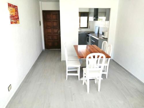 a kitchen and dining room with a table and chairs at Turyva Tarongers 5 - Modern 1-Bed Apartment & 5 Min to Peníscola Beach in Peñíscola
