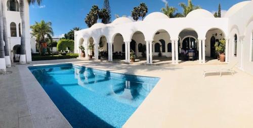 a swimming pool in front of a white house at Aldea del Bazar in Tehuacán