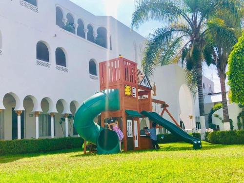 a playground in the grass next to a building at Aldea del Bazar in Tehuacán
