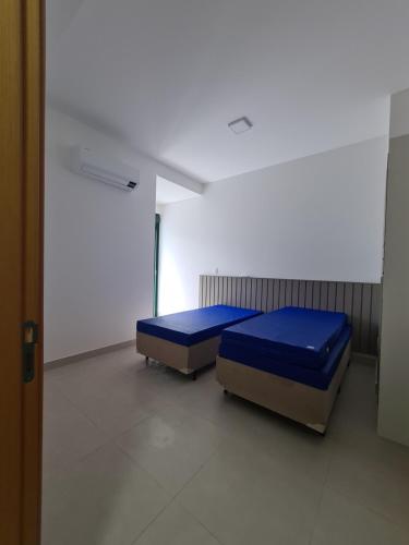 a room with two beds in a room at Apartamento Ubatuba Reserva DNA in Ubatuba