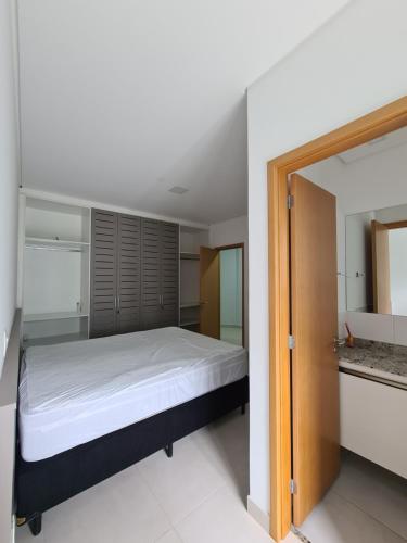 a bedroom with a bed and a sliding glass door at Apartamento Ubatuba Reserva DNA in Ubatuba