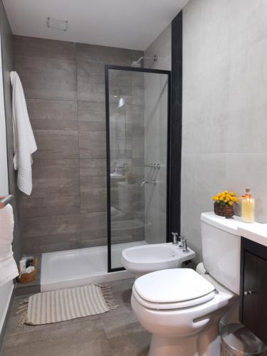 a bathroom with a white toilet and a shower at Estación Balcarce in Salta