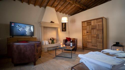 uma sala de estar com uma televisão de ecrã plano e um sofá em Locanda Dell'Oleificio em Mezzane di Sotto