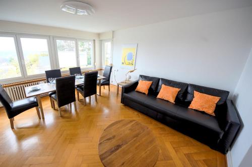 a living room with a black couch and a table at Luegete 28, Witikon Apartments in Zürich