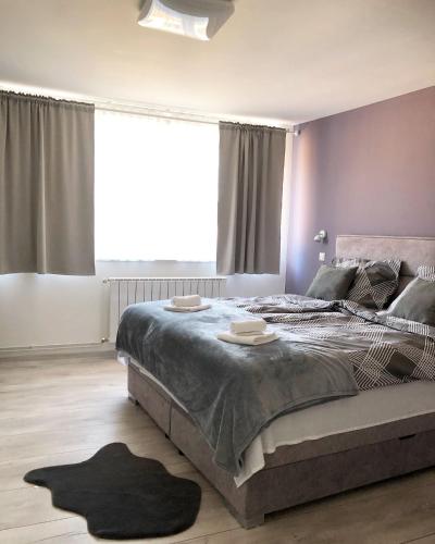 a bedroom with a large bed with two plates on it at Apartman Bloom in Osijek