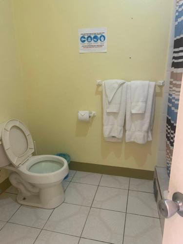 a bathroom with a toilet and towels at Cool Running Apartments in Saint Georgeʼs
