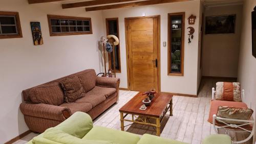 a living room with a couch and a table at Casa Lago Rapel, Las Cabras in Las Balsas
