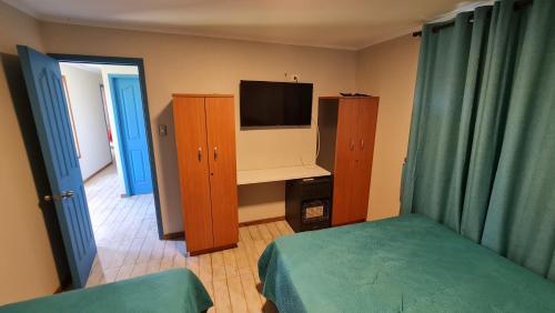 a bedroom with a bed and a tv and a cabinet at Casa Lago Rapel, Las Cabras in Las Balsas