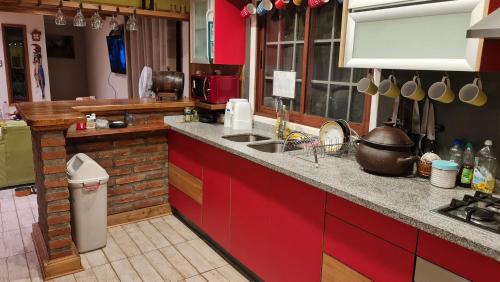a kitchen with red cabinets and a counter top at Casa Lago Rapel, Las Cabras in Las Balsas