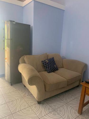 a brown couch in a living room with a refrigerator at Cool Running Apartments in Saint Georgeʼs
