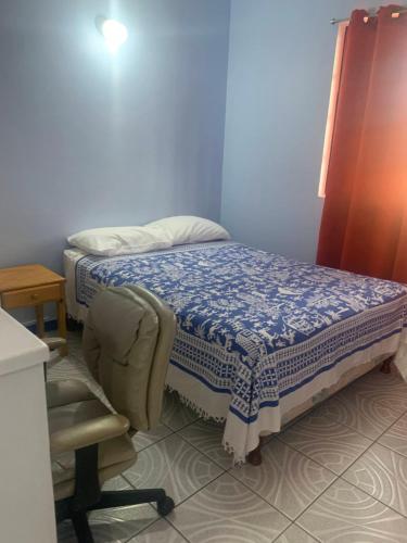 a small bedroom with a bed and a chair at Cool Running Apartments in Saint Georgeʼs