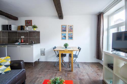 a small living room with a table and a kitchen at ROYALE APARTMENTS VIEUX LILLE 24H24H Access in Lille