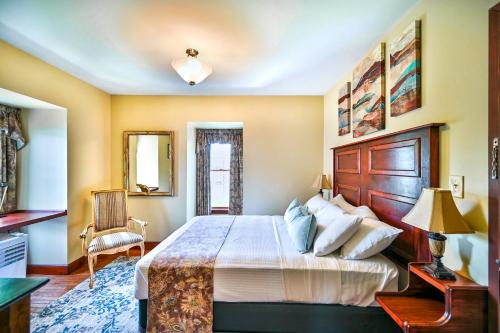 a bedroom with a large bed and a chair at Tom Quick Inn in Milford