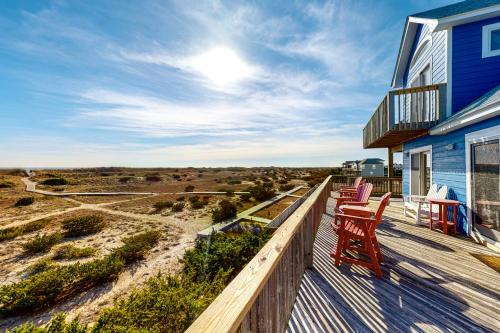 a deck with two chairs and a blue house at Alelleo's Retreat #13-S in Salvo