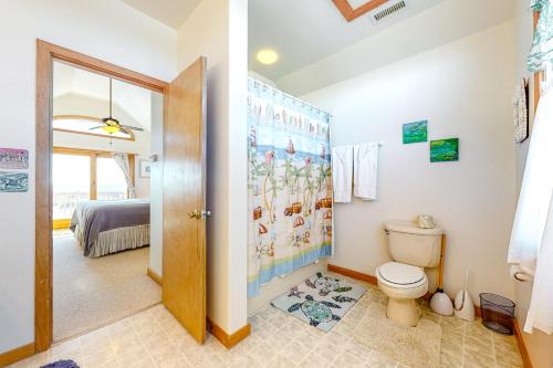 a bathroom with a toilet and a bedroom at Alelleo's Retreat #13-S in Salvo
