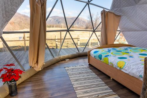 a bed in a canvas tent with a window at Brancoveanu Glamping in Văratici