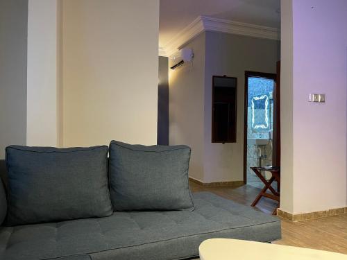 a living room with a gray couch in a room at LA ROCHELLE HOTEL in Yaoundé