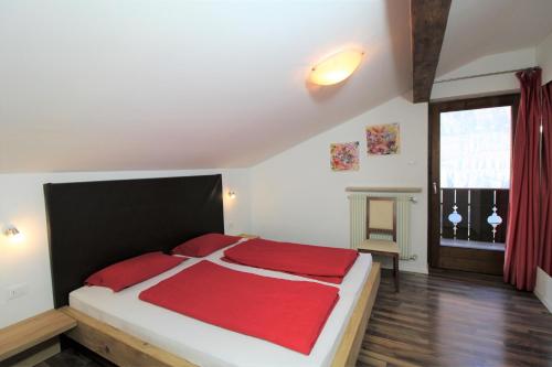a bedroom with a large bed with a red blanket at Bognerhof in Rifiano