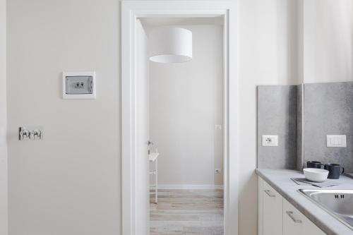 eine weiße Küche mit einem Waschbecken und einem Spiegel in der Unterkunft Cavour Luxury Home in Rom