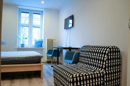 a room with a chair and a bed and a desk at One-room apartment on Ogarna St in the Old Town in Gdańsk