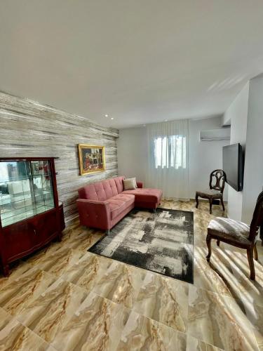 a living room with a pink couch and a television at SEA VIEW PARADISE 2 in Alexandria
