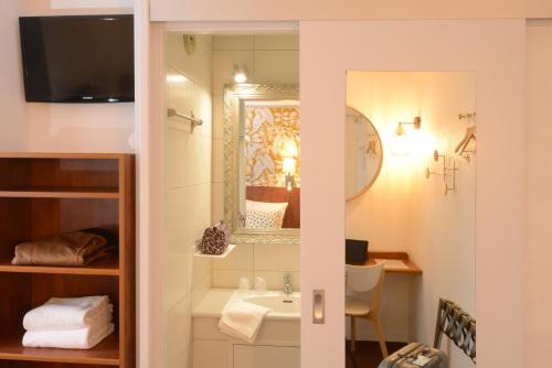 Un baño de Hotel Arc-En-Ciel Colmar Contact Hotel