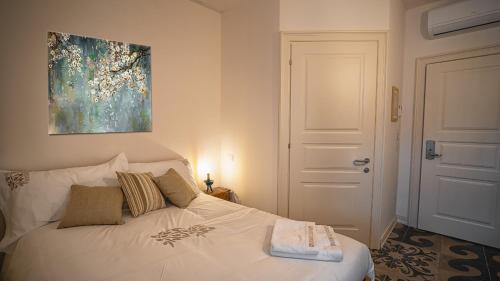 a bedroom with a white bed with a painting on the wall at Locanda Dell'Oleificio in Mezzane di Sotto