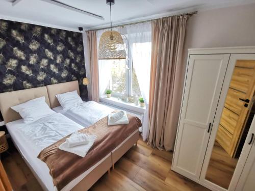 Schlafzimmer mit einem Bett und einem Fenster in der Unterkunft APARTAMENT NA WZGÓRZU in Jelenia Góra