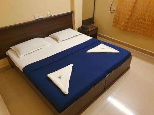 a bed in a room with a blue and white at BHIMAS INN -Puratchi Thalaivar Dr M G Ramachandran Central Railway Station Chennai in Chennai