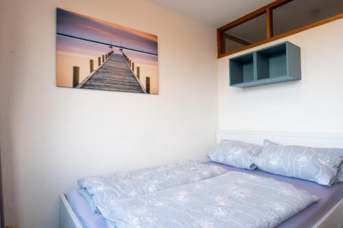 a bedroom with a picture of a pier on the wall at Ferienpark Steinhude - Neptun 115 in Wunstorf
