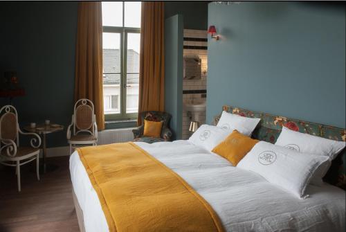um quarto com uma cama grande com lençóis brancos e laranja em Villa Servais em Halle