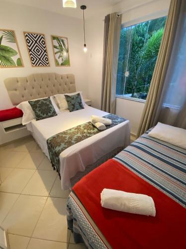 a bedroom with two beds and a window at Vila Noel Premium in Penedo