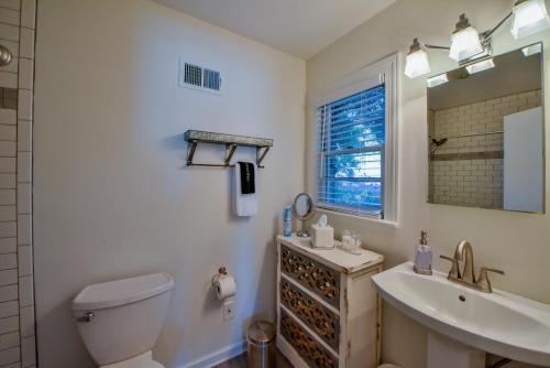 een badkamer met een toilet, een wastafel en een spiegel bij Sherwood House in Tuscaloosa