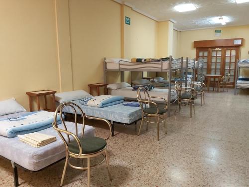 a room with several beds and chairs and tables at Casa Cerviño in Requejo