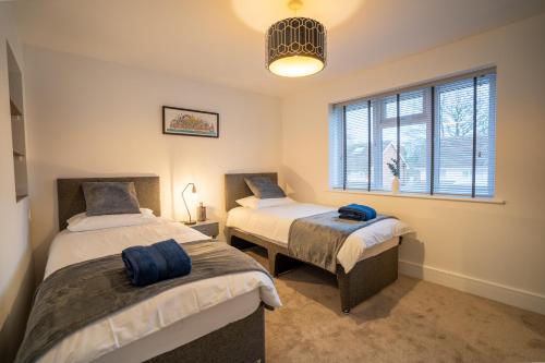 1 dormitorio con 2 camas y ventana en Mill Road Apartment First Floor, en Crawley