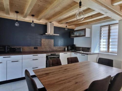 a kitchen with a wooden table and chairs at L'Ophrys in Les Déserts