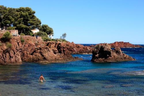 a person standing in the water in the ocean at Best Western Plus La Marina in Saint-Raphaël