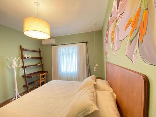 una camera da letto con un letto e un dipinto sul muro di Apto temático Pintura e Porcelana Centro Pomerode a Pomerode
