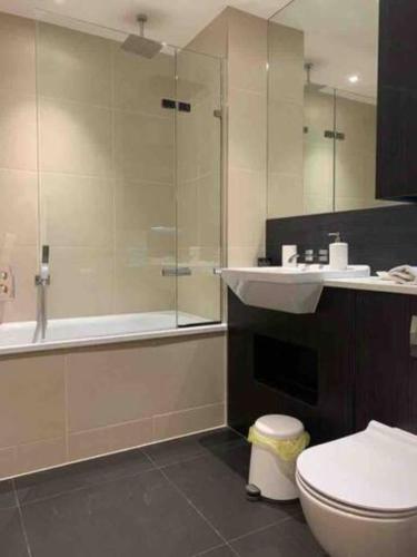 a bathroom with a toilet and a sink and a shower at GRAND SERVICED APARTMENTS***** in Croydon