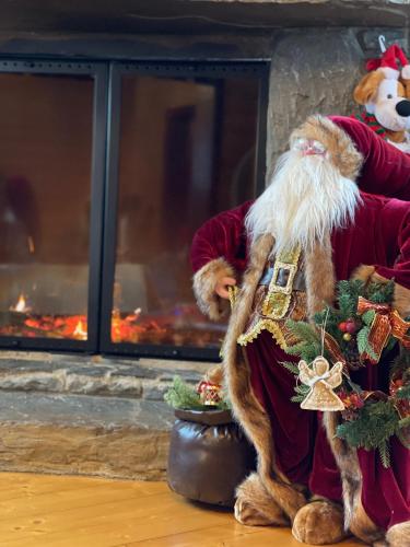 a santa claus standing in front of a fireplace at Вілла Софі in Verkhovyna
