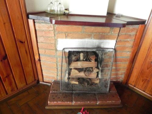 a brick fireplace in the middle of a room at Pousada Solar das Flores Maringá RJ Visconde de Mauá in Visconde De Maua