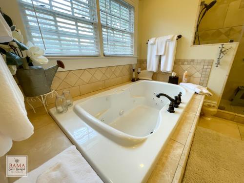 a large white tub in a bathroom with a window at Bama Bed and Breakfast - Magnolia Family Suite in Tuscaloosa