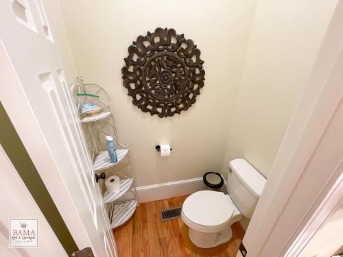 a bathroom with a toilet and a mirror on the wall at Bama Bed and Breakfast - Magnolia Family Suite in Tuscaloosa