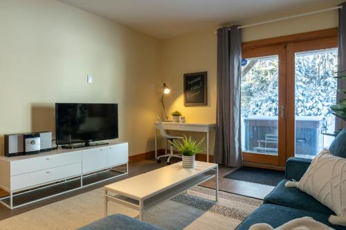 a living room with a couch and a tv at 4-Bedroom Chalet Fraternite in Lac-Superieur Tremblant in Lac-Superieur