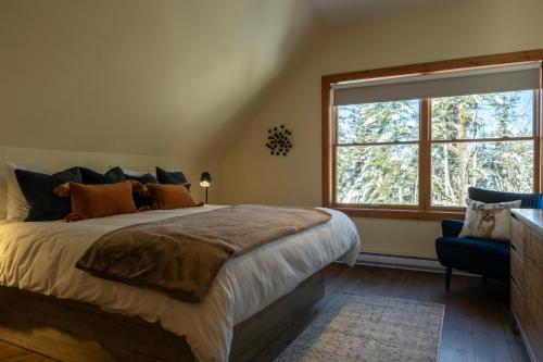 een slaapkamer met een groot bed en een raam bij 4-Bedroom Chalet Fraternite in Lac-Superieur Tremblant in Lac-Superieur