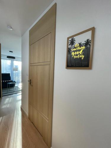 a hallway with a door and a picture on the wall at Apartamenty Marco Polo in Dziwnówek